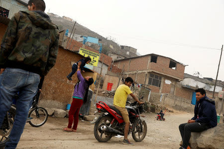 Residents of Nueva Union shantytown wait outside before the start of a friendly soccer match of Peru versus Saudi Arabia, in Villa Maria del Triunfo district of Lima, Peru, June 3, 2018. REUTERS/Mariana Bazo