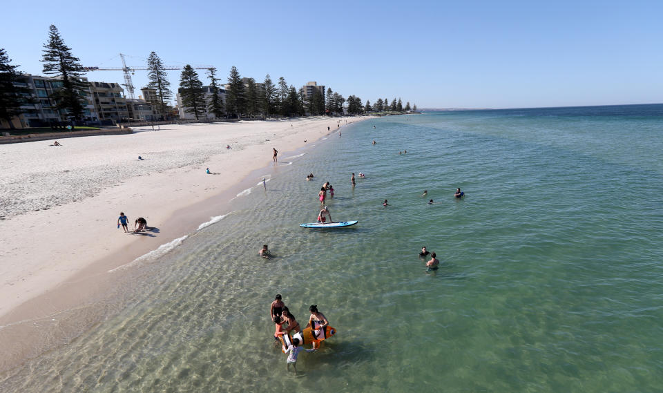 Beachgoers are seen at Glenelg Beach in Adelaide, aat the start of 2019, where the heat was around 40 degrees. Source: AAP Image/Kelly Barnes