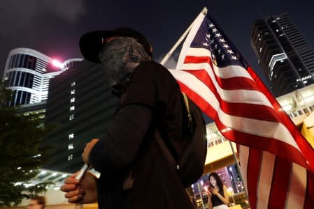 A demonstrator holds a U.S. flag as people gather at Lennon Wall at Admiralty district during the Mid-Autumn Festival, in Hong Kong