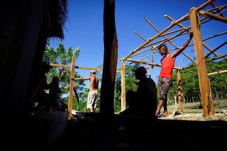 People take a break as they build a house at a farm in the village of Santo Domingo, in the Sierra Maestra, Cuba, March 29, 2018. REUTERS/Alexandre Meneghini