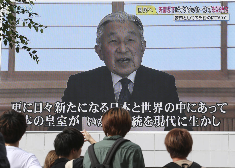 FILE - In this Aug. 8, 2016, file photo, pedestrian watch a screen displaying Japan's Emperor Akihito delivering a speech in Tokyo. The Japanese emperor, in a rare address to the public, signaled his apparent wish to abdicate by expressing concern about his ability to carry out his duties fully. Akihito’s Heisei era will end when he abdicates on April 30, 2019 in favor of his elder son, 58-year-old Crown Prince Naruhito, beginning a new, as yet unnamed era. (AP Photo/Koji Sasahara, File)