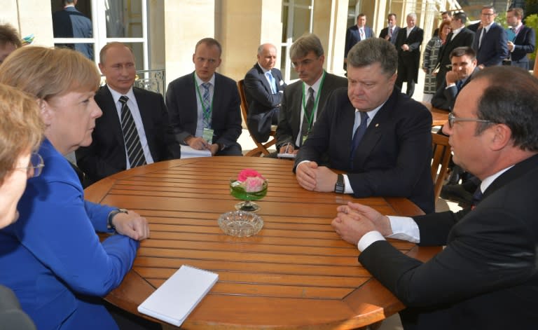 (From right to left) German Chancellor Angela Merkel, Russian President Vladimir Putin, Ukrainian President Petro Porochenko and French President Francois Hollande talk at the Elysee Palace, in Paris, on October 2, 2015