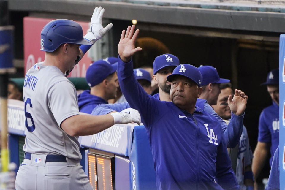 Los Angeles Dodgers manager Dave Roberts, right, high-fives Will Smith, left, after Smith's home run against the Cleveland Guardians during the first inning of a baseball game Tuesday, Aug. 22, 2023, in Cleveland. (AP Photo/Sue Ogrocki)
