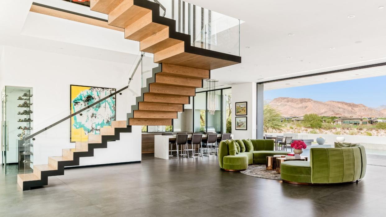  living room with stairs and green sofas and view of mountains 