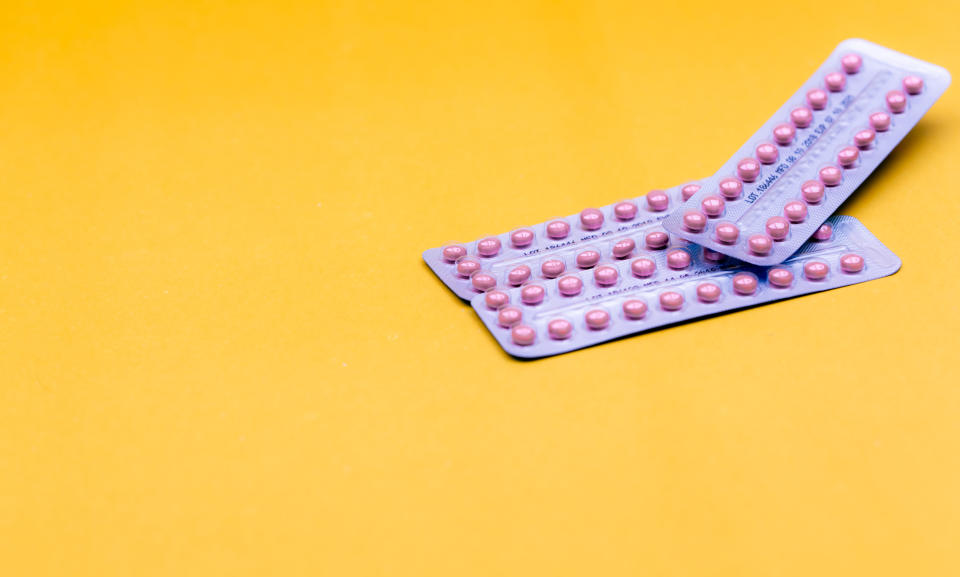 Blister packs of contraceptive pills on yellow background. Hormone pills for treatment hormone acne. Birth control pills. Estrogen and progesterone hormone pills. Pharmacy banner. Prescription drugs.