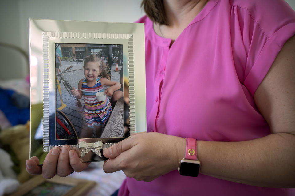 Jessica Riester Hart holds a photo of her daughter, 5-year-old Allie Hart, who was struck and killed in 2021 by a driver while riding her bicycle in a crosswalk near their home, Thursday, Sept. 14, 2023, in Washington. (AP Photo/Mark Schiefelbein)