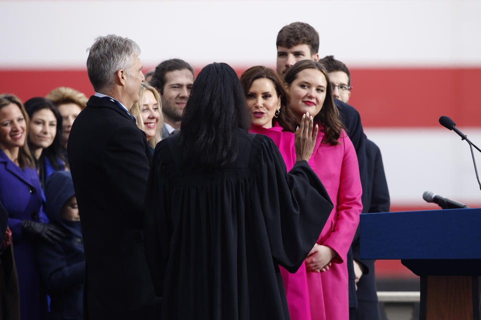 Standing with family members, Michigan Gov. Gretchen Whitmer, center, takes her oath of office administered by Michigan Supreme Court Justice Kyra Harris Bolden during inauguration ceremonies, Sunday, Jan. 1, 2023, outside the state Capitol in Lansing, Mich. (AP Photo/Al Goldis)