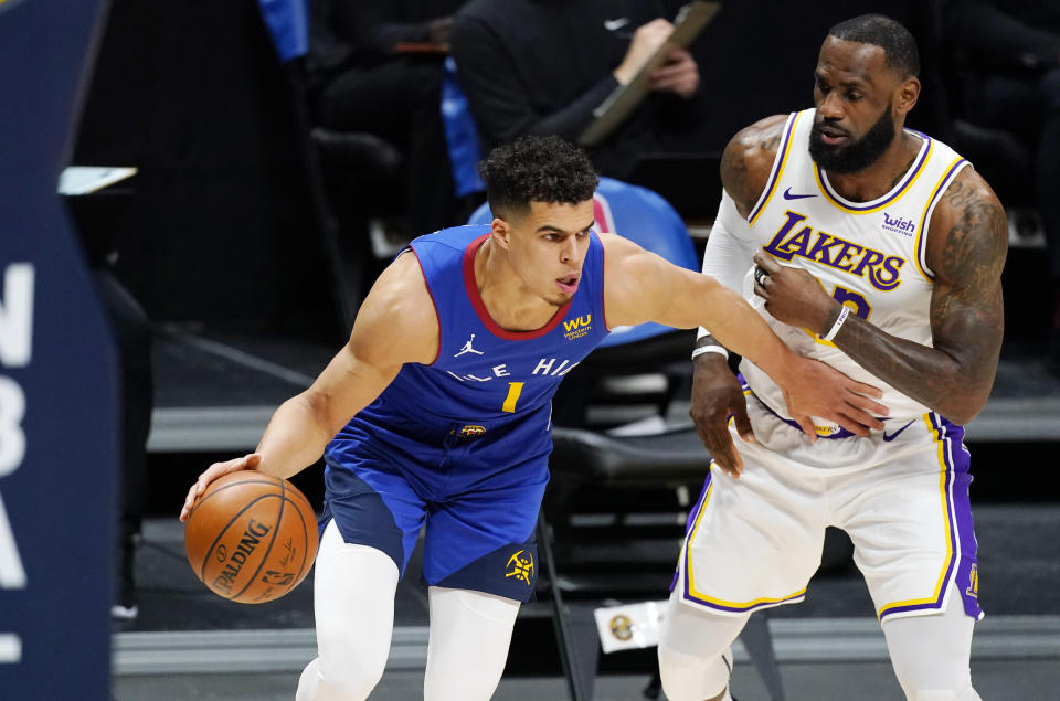 Denver Nuggets forward Michael Porter Jr., left, drives to the basket past Los Angeles Lakers forward LeBron James in the first half of an NBA basketball game Sunday, Feb. 14, 2021, in Denver. (AP Photo/David Zalubowski)