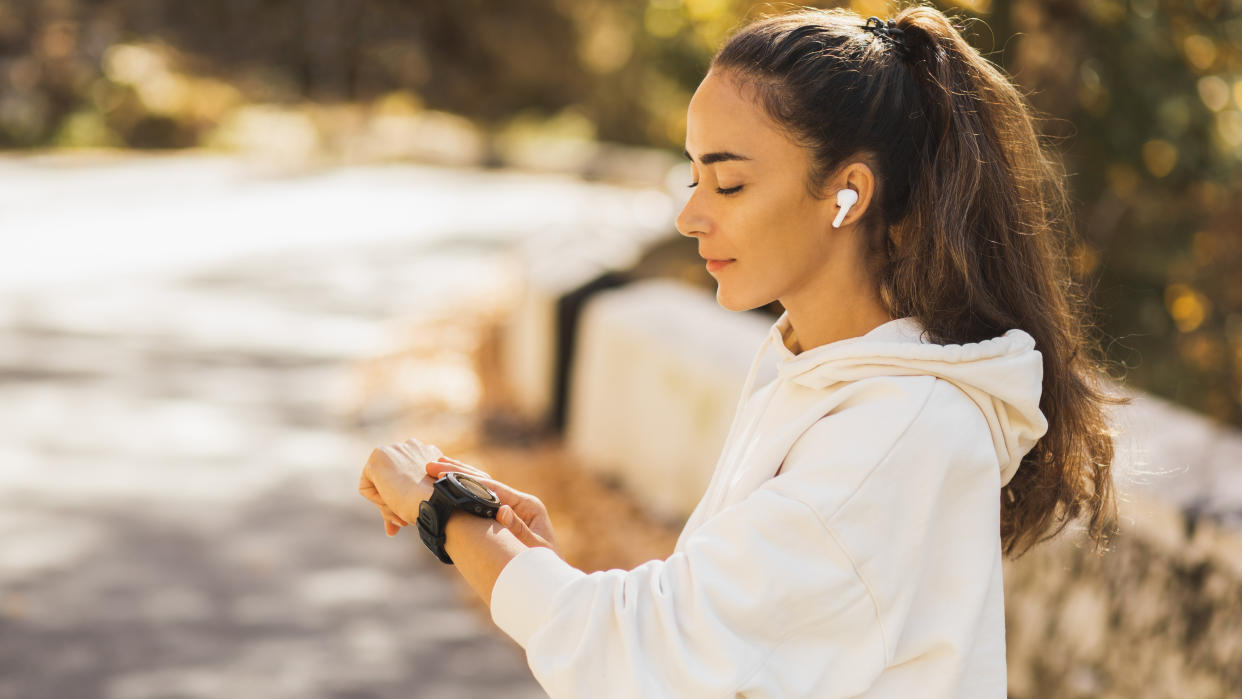  Woman checking sports watch during run 