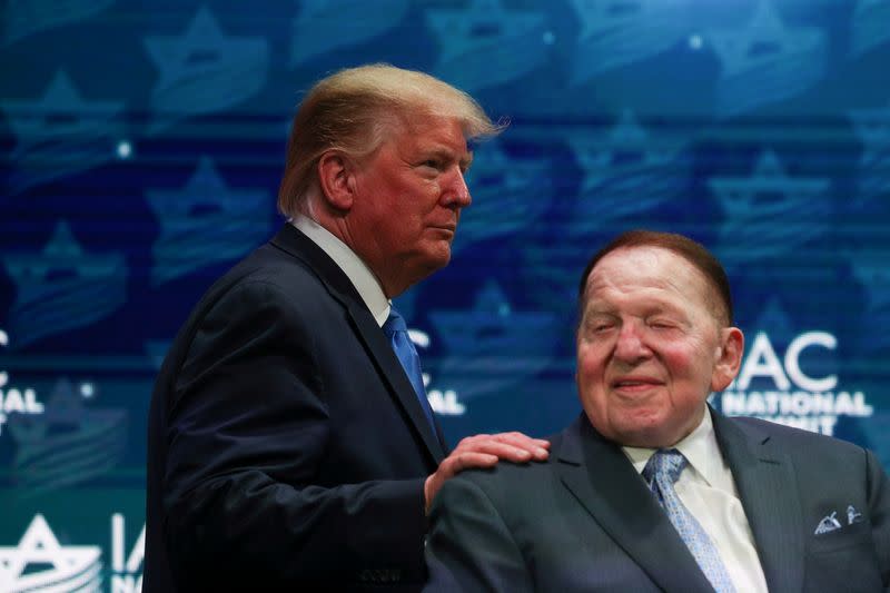 FILE PHOTO: U.S. President Trump greets Sheldon Adelson while taking the stage at the Israeli American Council National Summit in Hollywood, Florida