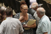 Jami Wallace, center, talks with other audience members during a break in a meeting of the National Transportation Safety Board to discuss and the Norfolk Southern Train Derailment Investigation Tuesday, June 25, 2024, in East Palestine, Ohio. (AP Photo/Sue Ogrocki)