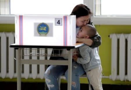 A mother kisses her son as she attends voting for the parliamentary elections at a polling station in Ulaanbaatar, Mongolia, June 29, 2016. REUTERS/Jason Lee