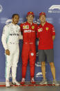 Ferrari driver Charles Leclerc of Monaco, center, poses with his teammate Sebastian Vettel of Germany, right, and Mercedes driver Lewis Hamilton of Britain after taking pole in the qualifying session for the Singapore Formula One Grand Prix at the Marina Bay City Circuit in Singapore, Saturday, Sept. 21, 2019. Hamilton finished second as Vettel was third. (AP Photo/Vincent Thian)