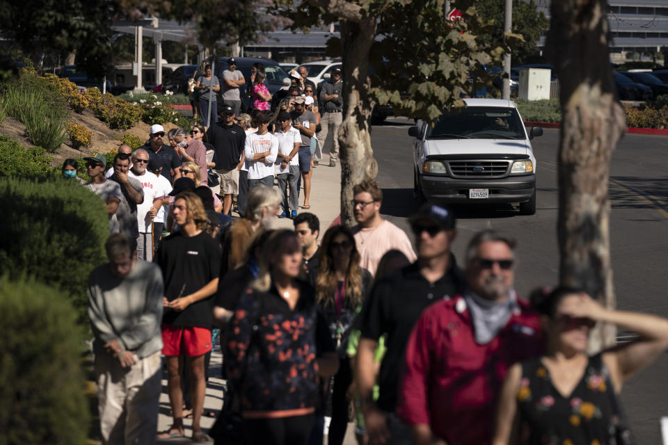 People wait in line to vote outside a vote center Tuesday, Sept. 14, 2021, in Huntington Beach, Calif. With Gov. Gavin Newsom's fate at stake, Californians on Tuesday cast the last of the ballots that will decide whether he continues to lead them or if the nation's most populous state veers in a more conservative direction amid anger over his actions during the COVID-19 pandemic. (AP Photo/Jae C. Hong)