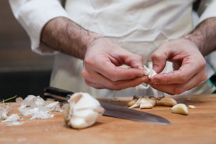 A chef peeling garlic