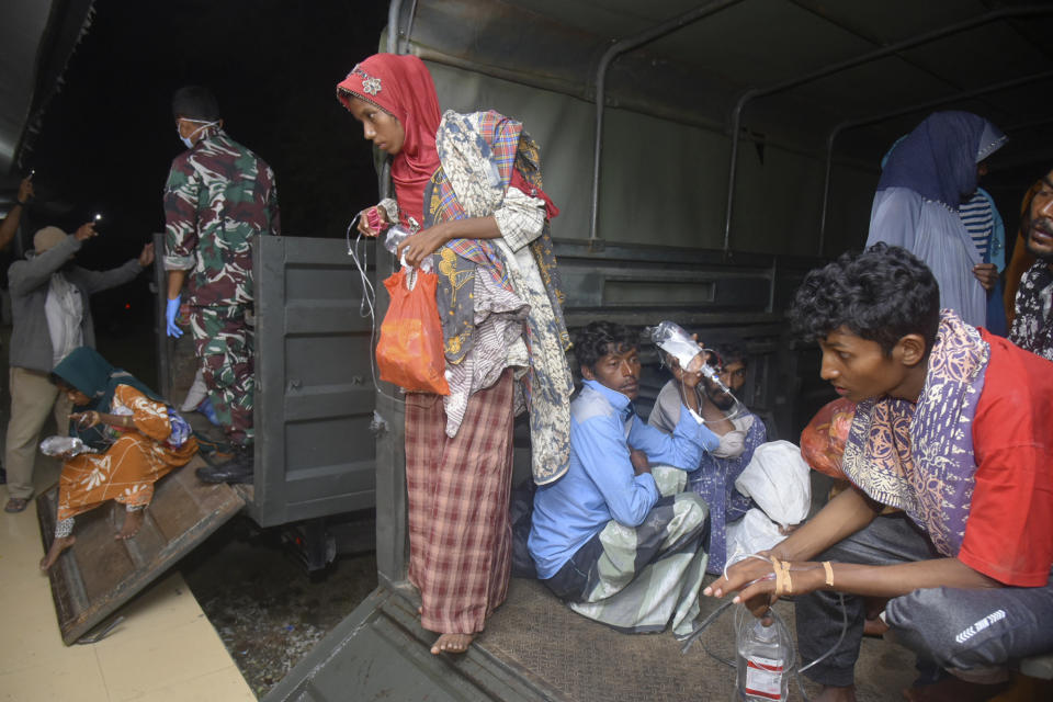 Ethnic Rohingya people sit inside a military truck upon arrival at a temporary shelter after their boat landed in Pidie, Aceh province, Indonesia, Monday, Dec. 26, 2022. A second group in two days of weak and exhausted Rohingya Muslims landed on a beach in Indonesia's northernmost province of Aceh on Monday after weeks at sea, officials said. (AP Photo/Rahmat Mirza)