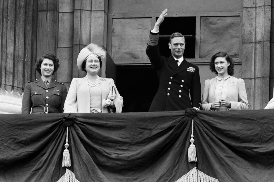 VE Day celebrations in London at the end of the Second World War. King George VI waves to the crowd from the balcony at Buckingham Palace during the celebrations, accomapnied by Princess Elizabeth, Queen Elizabeth and Princess Margaret. 8th May 1945.