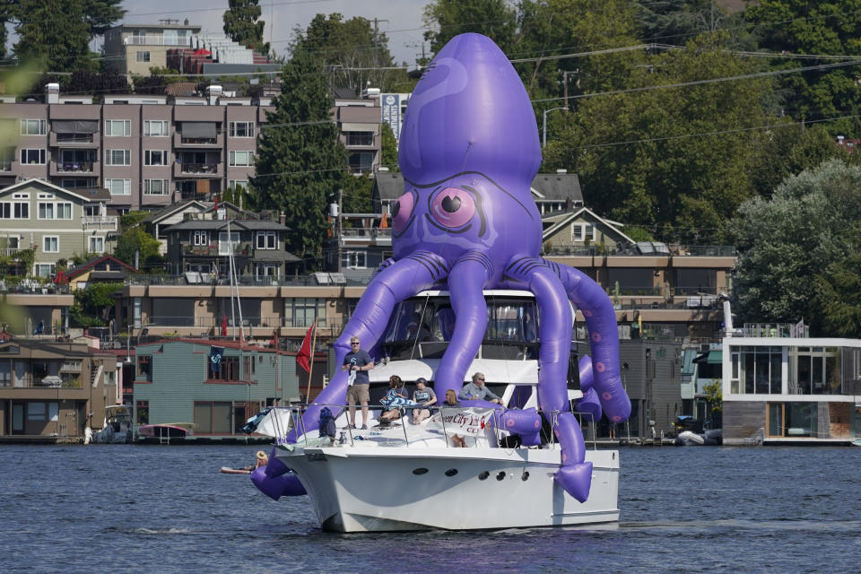 A boat with an inflatable octopus sails on Lake Union, Wednesday, July 21, 2021, in Seattle near the park where the Seattle Kraken NHL hockey team was holding its expansion draft event. (AP Photo/Ted S. Warren)