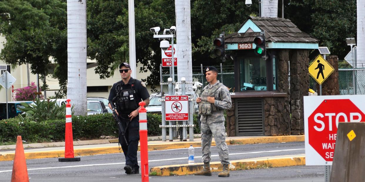 Security stand outside the main gate at Joint Base Pearl Harbor-Hickam, Wednesday, Dec. 4, 2019, in Hawaii.