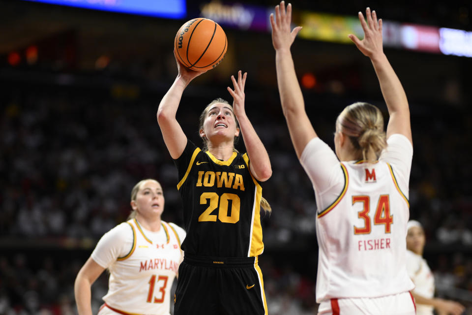 Iowa guard Kate Martin (20) shoots against Maryland guard Emily Fisher (34) and guard Faith Masonius (13) during the first half of an NCAA college basketball game, Saturday, Feb. 3, 2024, in College Park, Md. (AP Photo/Nick Wass)