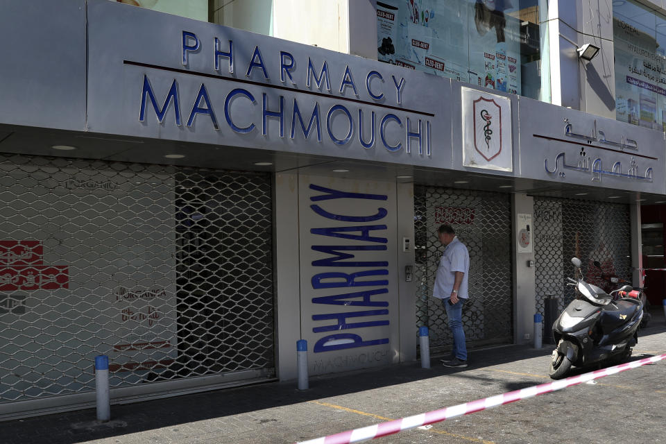 A man waits in front of a closed pharmacy in Beirut, Lebanon, Friday, June 11, 2021. Pharmacies across Lebanon began a two-day strike Friday, protesting severe shortages in medicinal supplies that is increasingly putting them in confrontation with customers and patients searching for medicines. The shortages are affecting everything from medicines for chronic illnesses to pain relievers to infant milk. (AP Photo/Bilal Hussein)