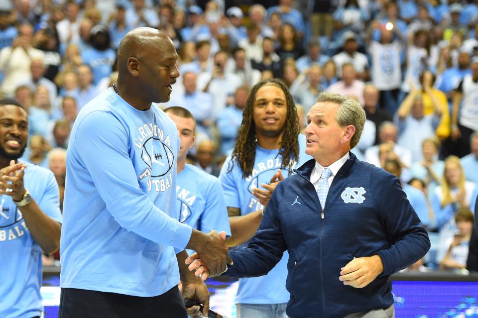 North Carolina all-time great Michael Jordan shakes hands with athletics director Bubba Cunningham, right, during a halftime ceremony in March 2017 at the Smith Center. (Bob Donnan / USA TODAY Sports)