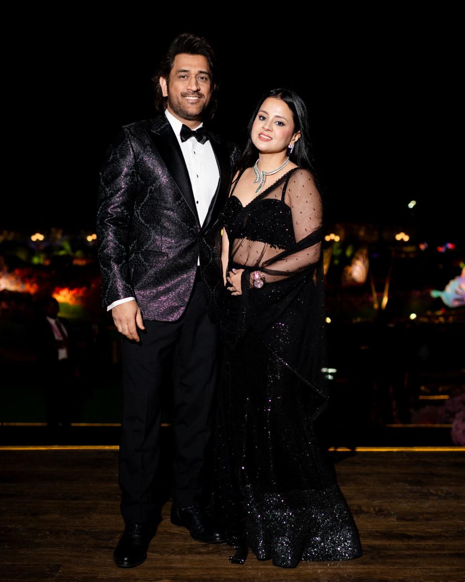 This handout photograph taken and released by Reliance on March 1, 2024, shows India's former cricket captain Mahendra Singh Dhoni (L) with his wife Sakshi Dhoni attending a three-day pre-wedding celebration hosted by billionaire tycoon Mukesh Ambani, for his son Anant Ambani and Radhika Merchant in Jamnagar.