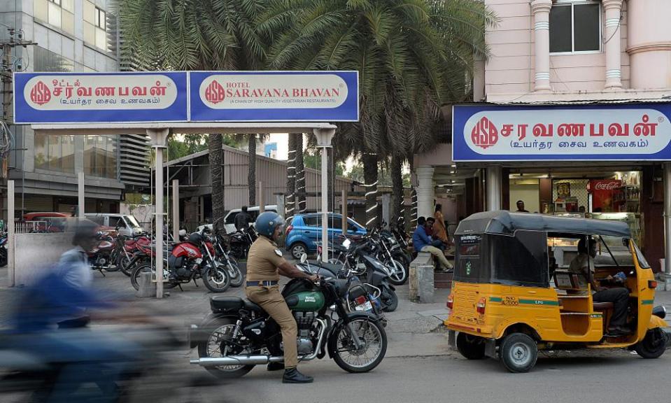 Vehicles pass a branch of Saravana Bhavan in Chennai