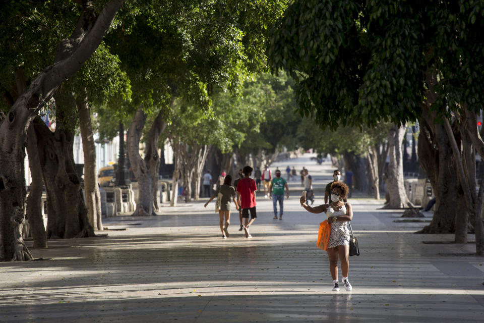 People walk through Paseo del Prado in Havana, Cuba, Monday, July 12, 2021, the day after protests against food shortages and high prices amid the coronavirus crisis. (AP Photo/Ismael Francisco)
