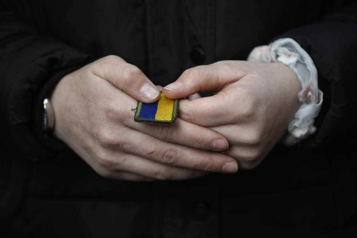 A daughter of one of the soldiers killed holds a patch from her father's uniform.