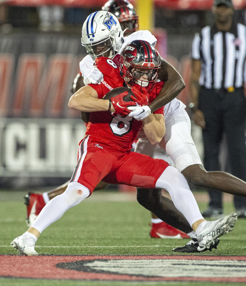 Western Kentucky wide receiver Easton Messer (8) is tackled by Middle Tennessee State cornerback De'Arre McDonald (28) during the first half of an NCAA college football game Thursday, Sept. 28, 2023, in Bowling Green, Ky. (Joe Imel/Daily News via AP)