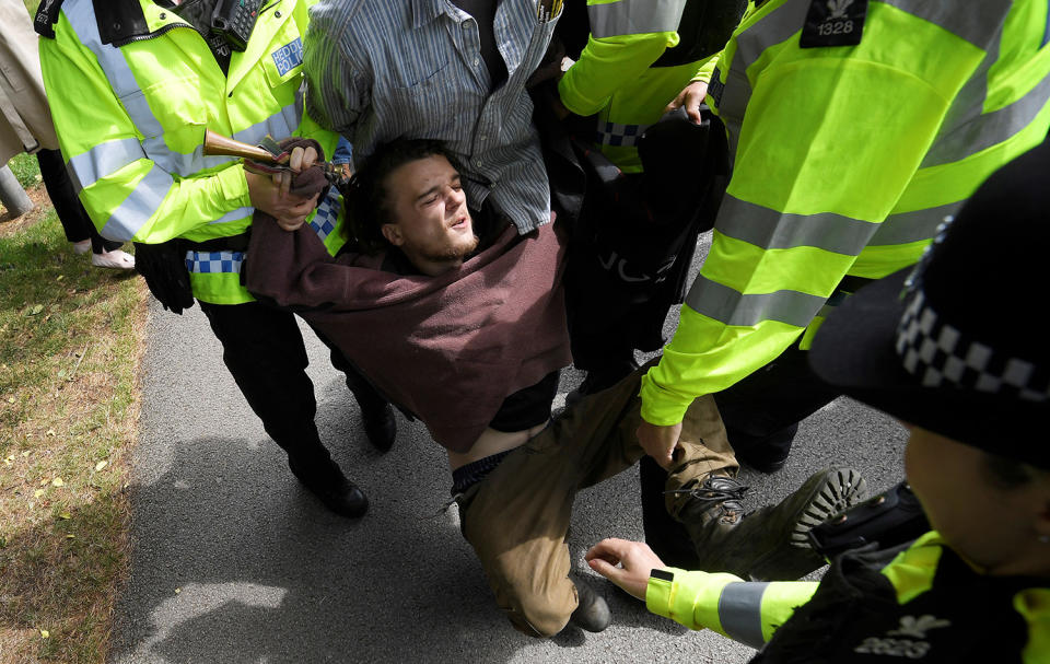 Police officers detain a man outside an election campaign event in Wrexham