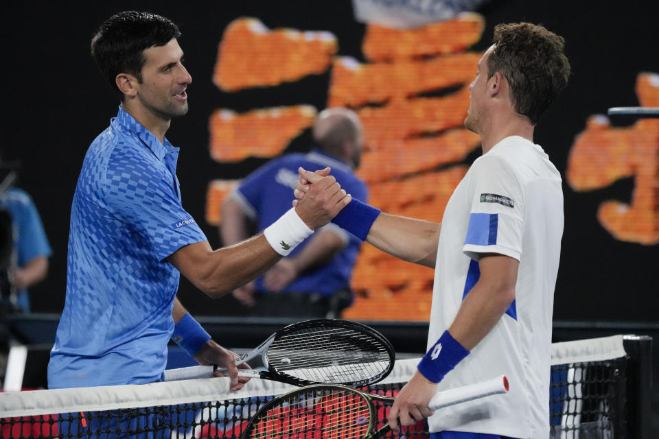 Novak Djokovic, left, of Serbia is congratulated by Roberto Carballes Baena of Spain following their first round match at the Australian Open tennis championship in Melbourne, Australia, Wednesday, Jan. 18, 2023. (AP Photo/Aaron Favila)