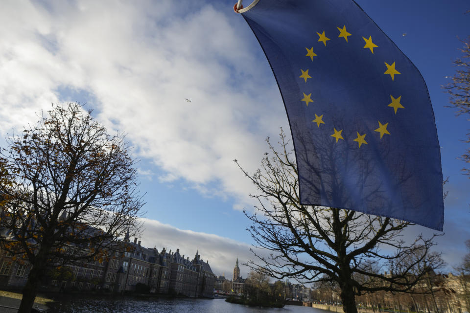 FILE - A European Union flag flies outside parliament building, rear left, one day after the far-right Party for Freedom of leader Geert Wilders won the most votes in a general election, in The Hague, Netherlands, Thursday Nov. 23, 2023. In June, voters in the 27 member states of the European Union will elect their next Parliament for a five-year term. Analysts say that far-right parties, now the sixth-largest group in the assembly, are primed to gain seats – and more influence over EU policies affecting everything from civil rights to gender issues to immigration. (AP Photo/Peter Dejong, File)