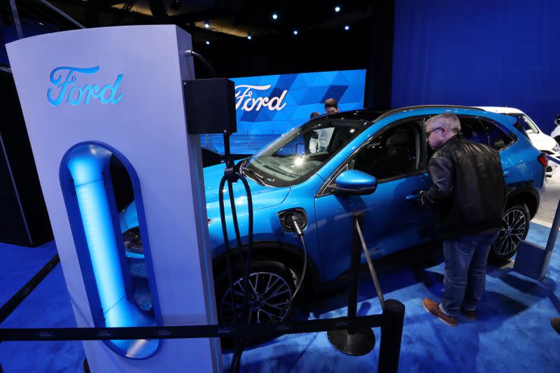 A visitor views a hybrid Ford Escape FWD small SUV at the Canadian International Auto Show in Toronto