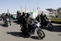 Houthi police troopers ride on motorcycles in Sanaa