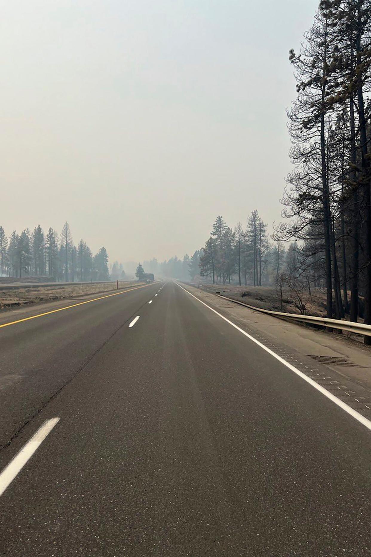 This photo provided by the Washington State of Transportation smoke from wildfires fill the sky at Salnave/SR 902 interchange in Spokane County on Saturday. A fast-moving wildfire has destroyed at least 185 structures, closed a major highway and left one person dead.