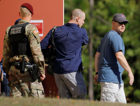 Bowe Bergdahl (C), who was demoted and dishonorably discharged from the U.S. Army for abandoning his post in Afghanistan, wears civilian clothes as he is escorted out of the courthouse at the conclusion of his court martial at Fort Bragg, North Carolina, U.S., November 3, 2017. REUTERS/Jonathan Drake