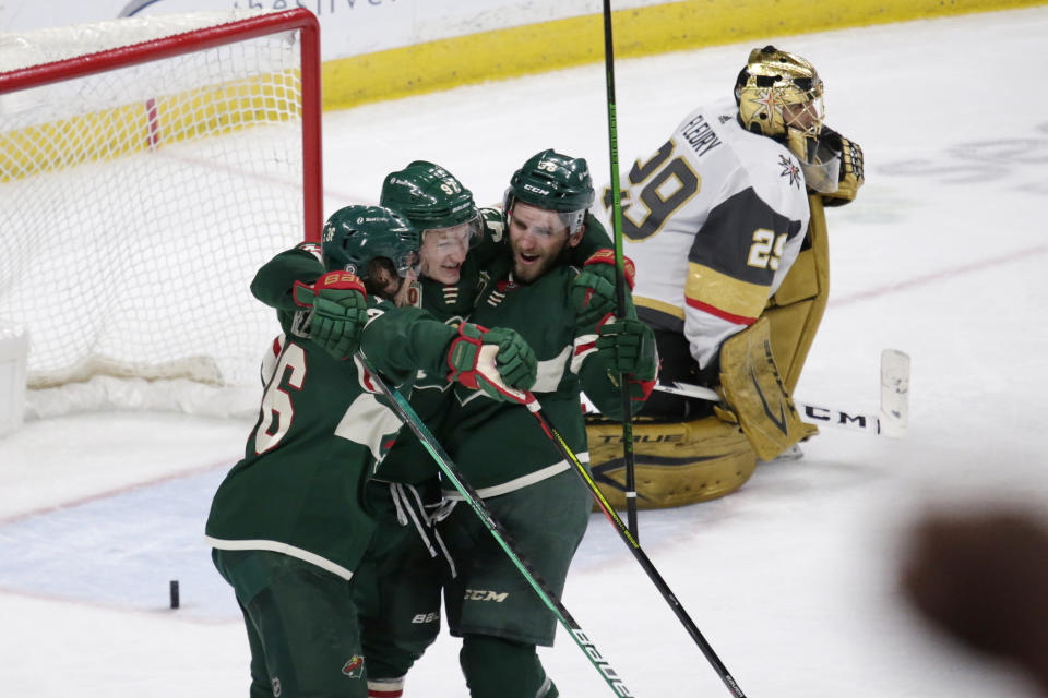 Minnesota Wild left wing Kirill Kaprizov (97) celebrates his goal with right wing Mats Zuccarello (36) and right wing Ryan Hartman (38) as Vegas Golden Knights goaltender Marc-Andre Fleury (29) reacts during the third period during an NHL hockey game Wednesday, May 5, 2021, in St. Paul, Minn. The Golden Knights won 3-2 in overtime. (AP Photo/Andy Clayton-King)