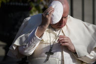 Pope Francis holds onto his skull cap in the wind during his visit to the Citadelle de Quebec, Wednesday, July 27, 2022, in Quebec City, Quebec City, Quebec. Pope Francis is on a "penitential" six-day visit to Canada to beg forgiveness from survivors of the country's residential schools, where Catholic missionaries contributed to the "cultural genocide" of generations of Indigenous children by trying to stamp out their languages, cultures and traditions. (AP Photo/John Locher)