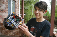 Danylo Boichuk, 12, shows his one of his LEGO constructions during an interview at his home in the village of Gorenichi outside Kyiv, Ukraine, on Tuesday, May 5, 2020. Ukraine has been under a COVID-19 coronavirus quarantine since March 12. Danylo envies his cat, Kari, who is able to escape from the family house and run free. Because of the pandemic, his family had to cancel a vacation in Bulgaria, and he worries a lot about closed borders. (AP Photo/Efrem Lukatsky)