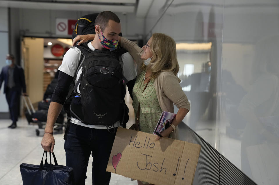 Debbie Greaves embraces her son Josh, who she's not seen for nine month as he arrives on a flight from Sweden, at Terminal 5 of Heathrow Airport in London, Monday, Aug. 2, 2021. Travelers fully vaccinated against coronavirus from the United States and much of Europe were able to enter Britain without quarantining starting today, a move welcomed by Britain's ailing travel industry. (AP Photo/Matt Dunham)