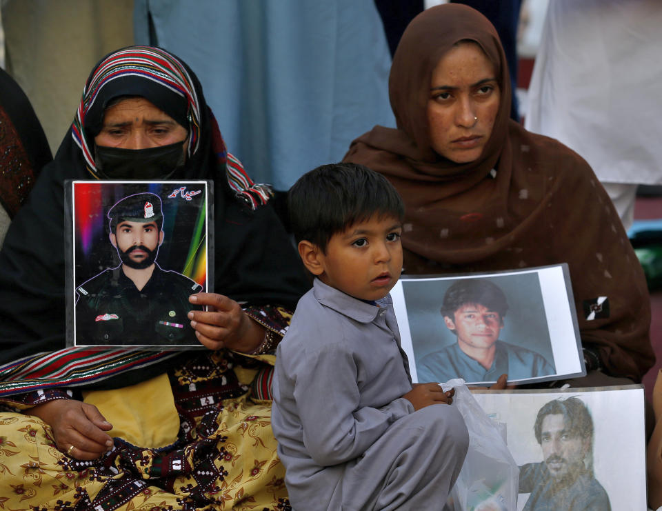 Women hold portraits of their missing family members during their sit-in protest, in Islamabad, Pakistan, Saturday, Feb. 20, 2021. Dozens of relatives of Baluch missing persons, allegedly taken away by security agencies from restive Baluchistan province, Saturday ended their ten-day protest sleeping in the February cold near Pakistan parliament in capital Islamabad as minster for Human Rights assured their demand for recovery of loved ones would be taken seriously. (AP Photo/Anjum Naveed)