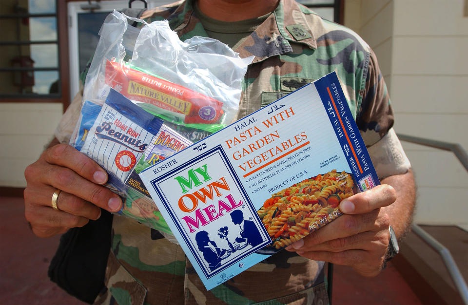 A U.S. Marine displays the daily lunch ration for Taliban and Al Qaeda detainees at Camp X-Ray February 6, 2002 in Guantanamo Bay, Cuba. There are 156 Al Qaeda and Taliban prisoners currently being held in the camp, and they are given three Muslim-friendly meals a day. (Photo by Chris Hondros/Getty Images)