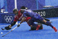 Japan's Kota Watanabe (31) leaps for a loose ball against New Zealand goalkeeper Leon Hayward in a downpour during a men's field hockey match at the 2020 Summer Olympics, Tuesday, July 27, 2021, in Tokyo, Japan. (AP Photo/John Minchillo)
