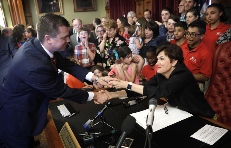 FILE - In this May, 4, 2018, file photo, Iowa Gov. Kim Reynolds, right, greets Iowa Senate Majority Leader Jack Whitver, left, after a bill signing ceremony in her formal office at the Statehouse in Des Moines, Iowa. Nearly 50 years after Iowa moved to reduce partisanship in its court system, Republicans who control the governor's office and the Legislature say it's time to give politicians greater control. (AP Photo/Charlie Neibergall, File)