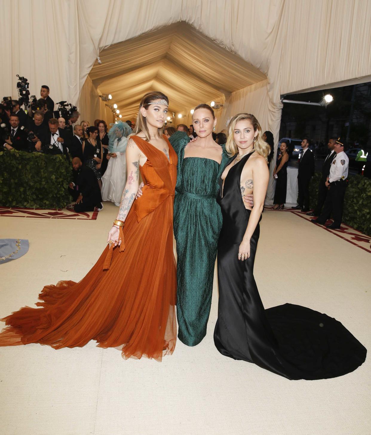 Paris Jackson, Stella McCartney and Singer-Songwriter Miley Cyrus arrive at the Metropolitan Museum of Art Costume Institute Gala (Met Gala) to celebrate the opening of “Heavenly Bodies: Fashion and the Catholic Imagination” in the Manhattan borough of New York, U.S., May 7, 2018. REUTERS/Carlo Allegri