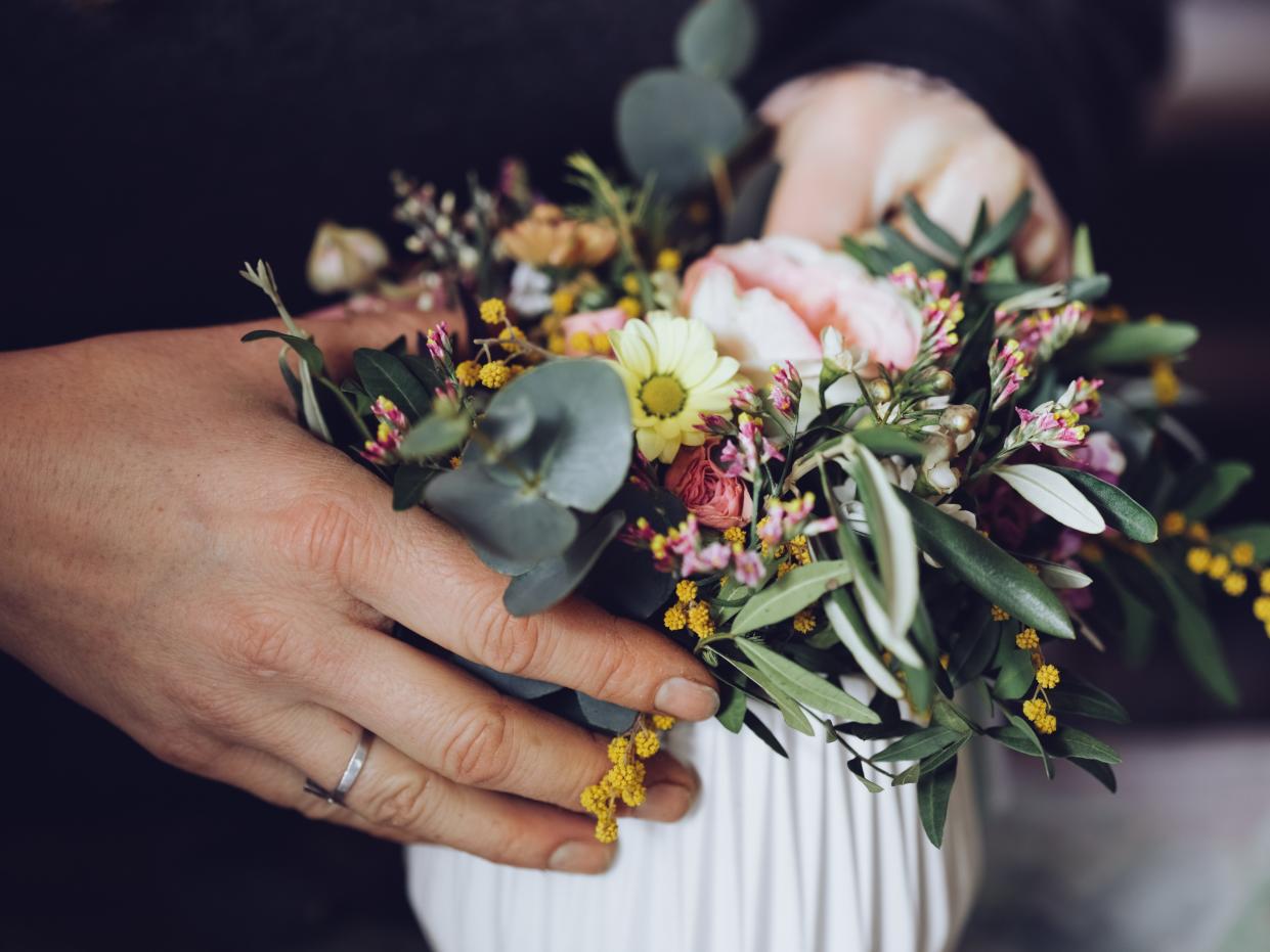 Hands arranging flowers.