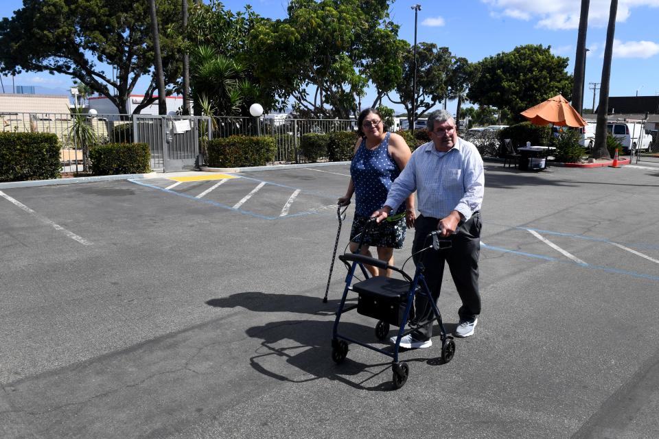 Charles and Myrna Szabo walk through the parking lot of the former Vagabond Inn in Oxnard on Monday, Sept. 19, 2022. The former motel provides temporary shelter for individuals facing homelessness through the state's Project Roomkey.