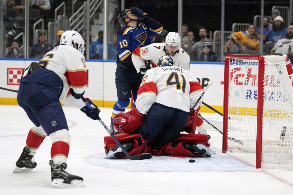 St. Louis Blues' Brayden Schenn (10) holds his face as the puck slips through the legs of Florida Panthers goaltender Anthony Stolarz (41) during the second period of an NHL hockey game Tuesday, Jan. 9, 2024, in St. Louis. (AP Photo/Jeff Roberson)